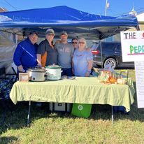 A cook team at their table under a blue canopy